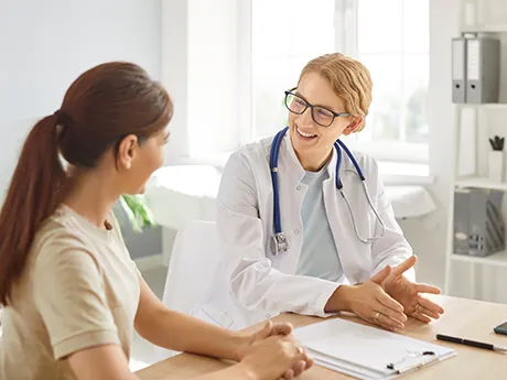 Medizinische Beratung zur Darmsanierung mit PMA-Zeolith – vertrauensvoll und evidenzbasiert Eine Ärztin spricht freundlich mit einer Patientin am Schreibtisch. Das Bild symbolisiert Vertrauen, medizinische Beratung und Unterstützung bei Darmtherapie mit PMA-Zeolith.